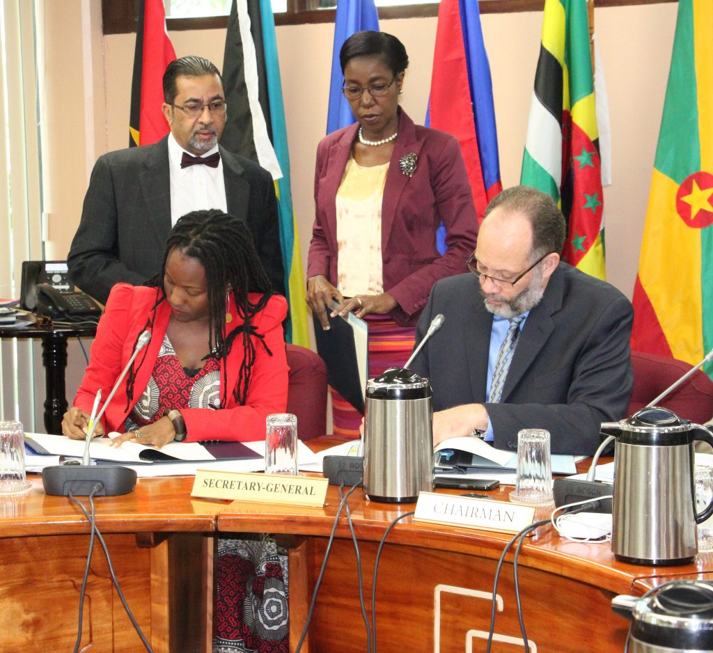 From left, UN-Women representative. Ms. Toni Brodber and CARICOM Secretary-General, Amb. Irwin LaRocque sign the MOU. Standing are Mr. Neville Bissember and Ms. Barbara Vandyke, Office of the CARICOM Secretary-General