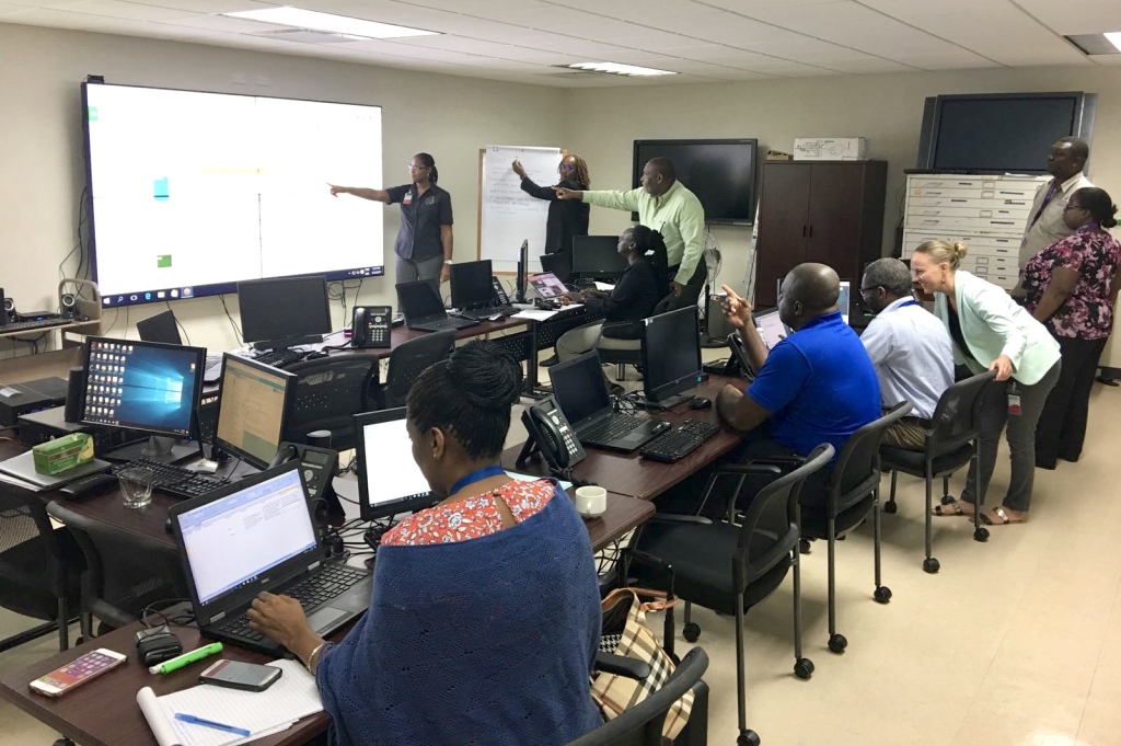 Representatives from the 4 Regional agencies and partners discussing events being logged into the Virtual Crisis Room in CDEMA's Regional Coordination Centre. (Photo via CDEMA)
