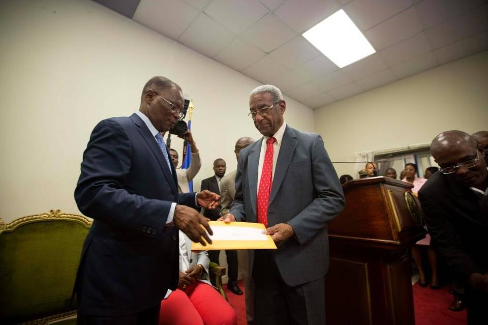 Interim President Jocelerme Privert, left, receives the election report from the president of the verification commission Francois Benoit, at the national palace in Port-au-Prince, Haiti, Monday, May 30, 2016. (Photo via Dieu Nalio Chery AP)